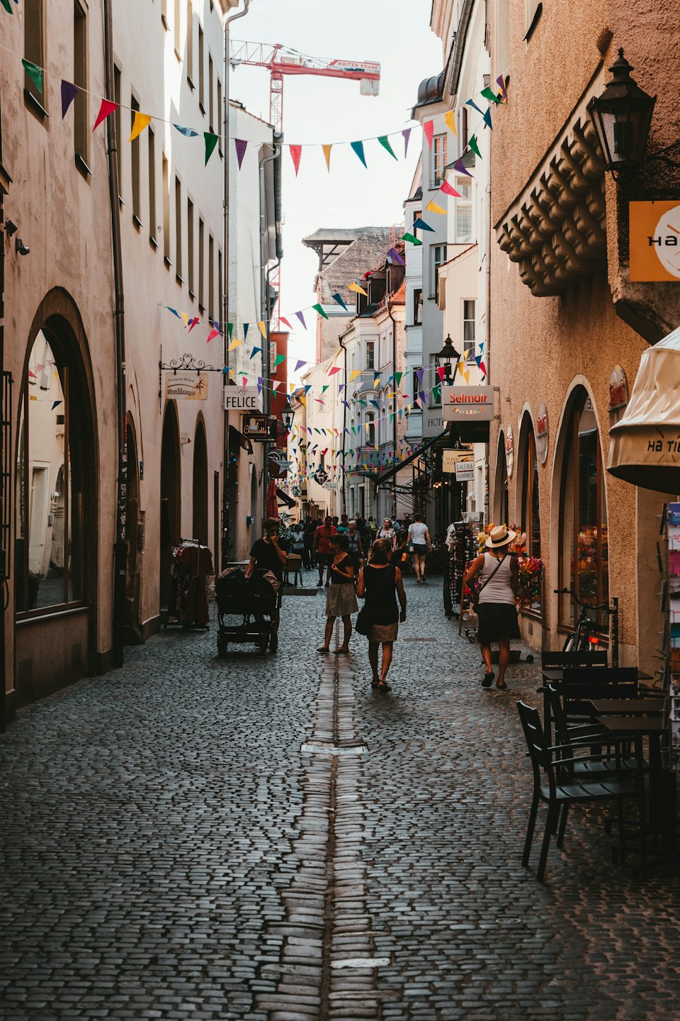 Persone che camminano su una strada acciottolata in una città europea.